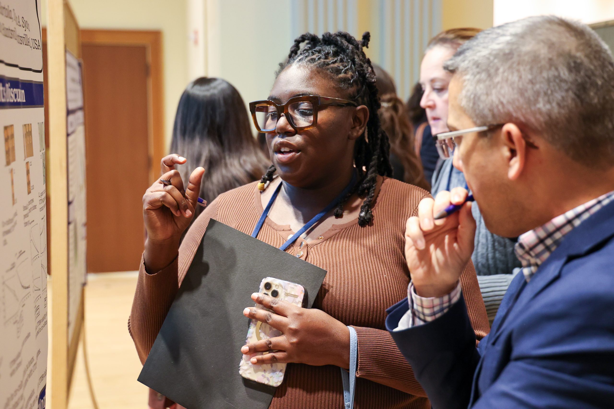 Presenter explains their poster to an attendee 